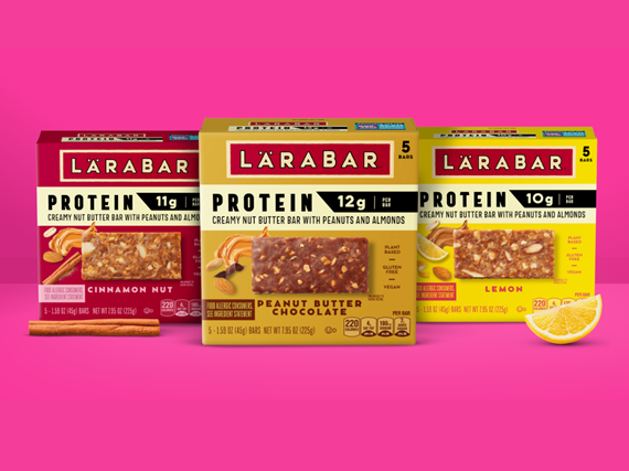 LÄRABAR Protein bars in Cinnamon Nut, Peanut Butter Chocolate and Lemon flavors displayed in colorful packaging against a bright pink background, highlighting the brand’s new plant-based protein bar lineup.