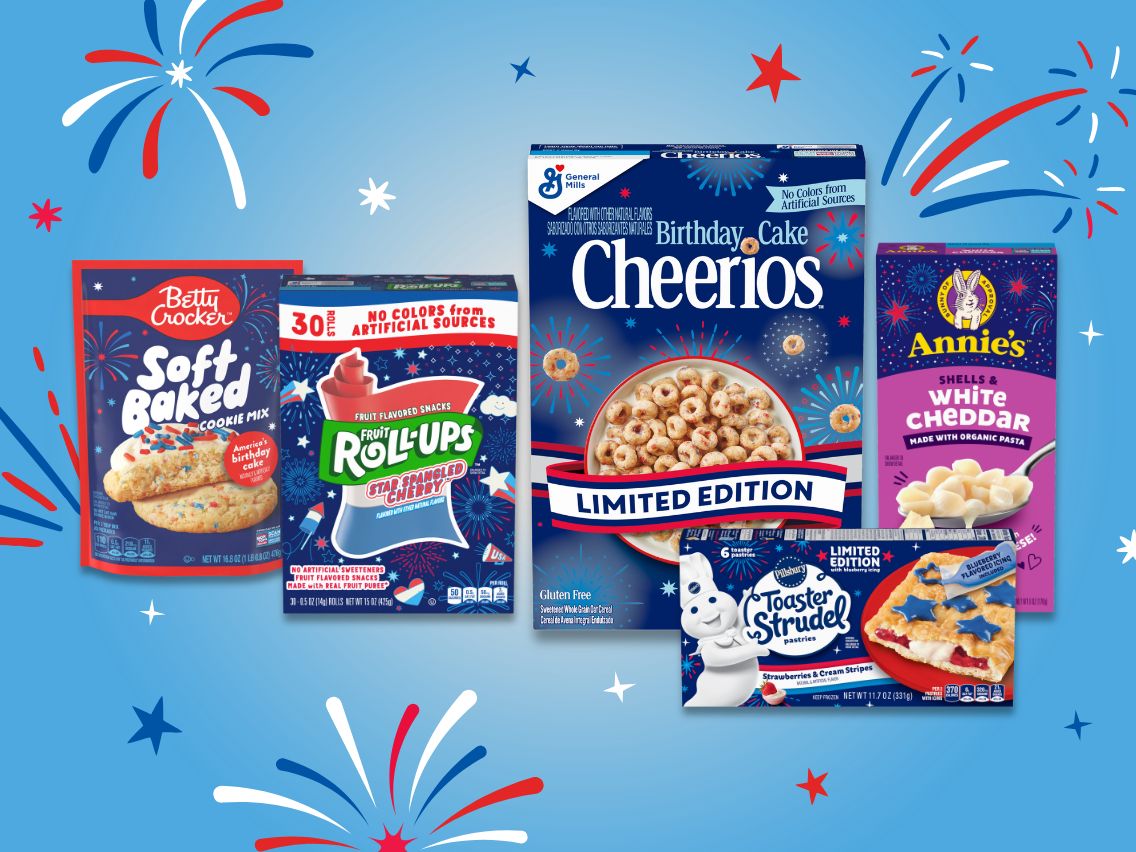 ​Assortment of General Mills limited-edition America’s 250th birthday-themed products displayed against a blue background with red, white and blue fireworks graphics, including Betty Crocker Soft Baked Cookie Mix, Fruit Roll-Ups, Birthday Cake Cheerios, Annie’s White Cheddar Shells and Pillsbury Toaster Strudel.